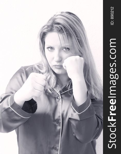 A young woman focused and ready to fight with a lot of attitude.. Control, concentration & contemplation. .She's holding her fists up, staring at camera and preparing to punch.. attractive, sexy,tough & feminine Monochrome image. A young woman focused and ready to fight with a lot of attitude.. Control, concentration & contemplation. .She's holding her fists up, staring at camera and preparing to punch.. attractive, sexy,tough & feminine Monochrome image