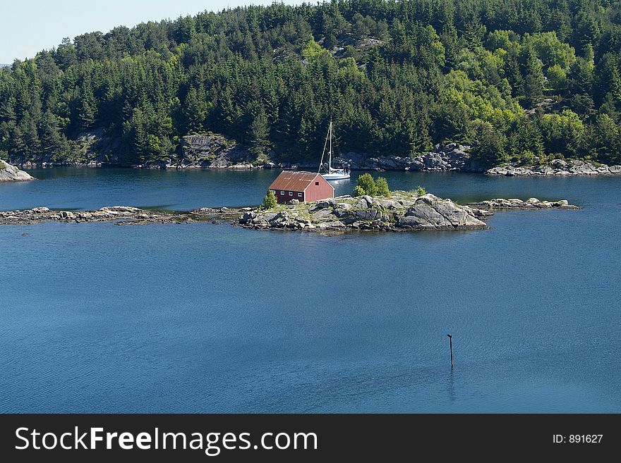 Sailboat at anchor behind island in a fjord at the Norwegian south coast, between Farsund and Loshavn. Sailboat at anchor behind island in a fjord at the Norwegian south coast, between Farsund and Loshavn.