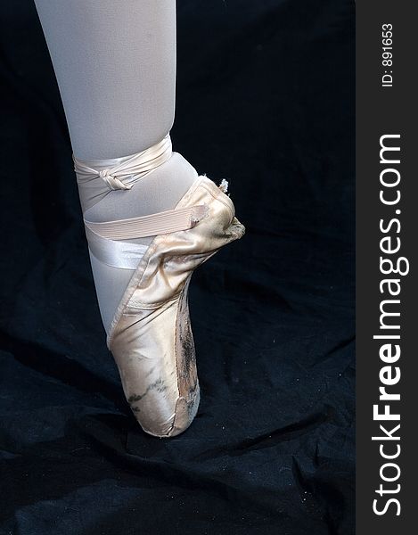 A view of a ballerina's foot as she stands on Pointe. A view of a ballerina's foot as she stands on Pointe
