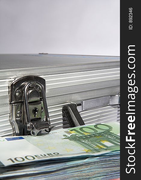 Aluminium suitcase with a pile of european papermoney. Aluminium suitcase with a pile of european papermoney