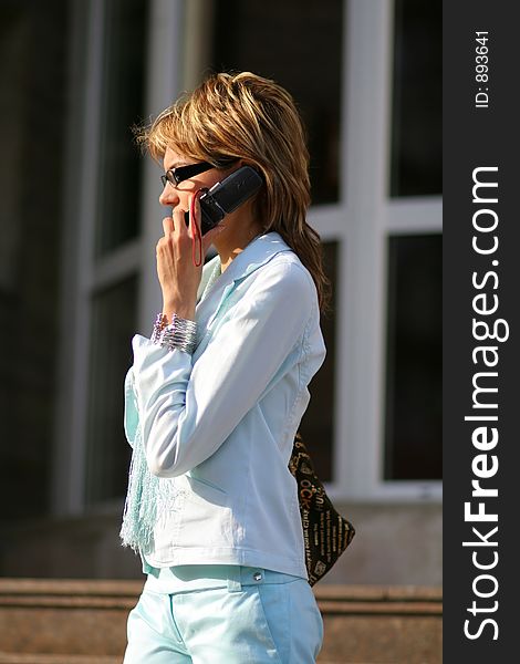 young women walking on the street and talking on the mobile phone. young women walking on the street and talking on the mobile phone