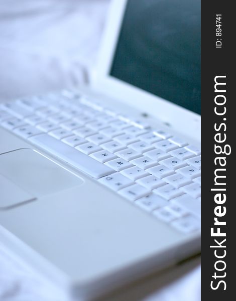 White laptop on top of white sheet. White laptop on top of white sheet