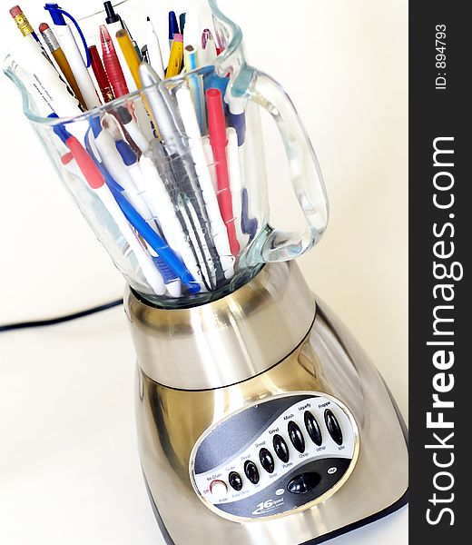 Multi-speed brushed metal blender full of pens and pencils.