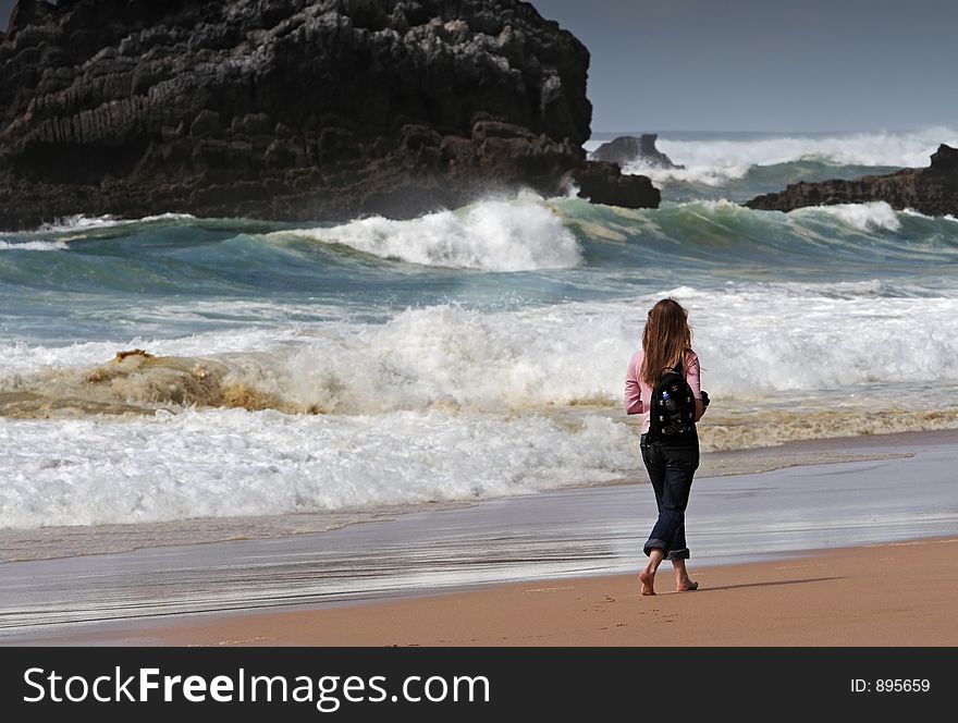 Girl walking on the beach barefoot