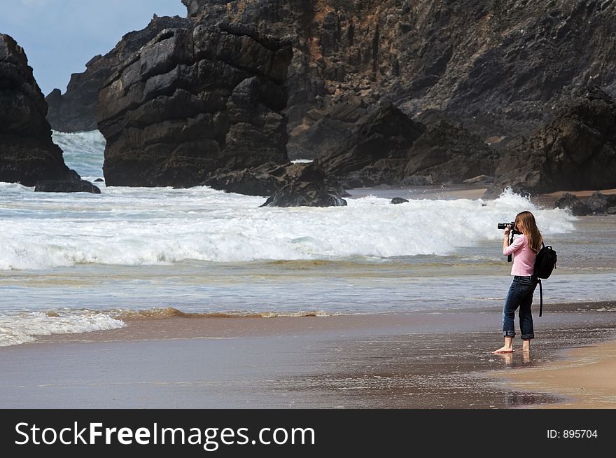 Girl taking a picture on the rocky beach. Girl taking a picture on the rocky beach