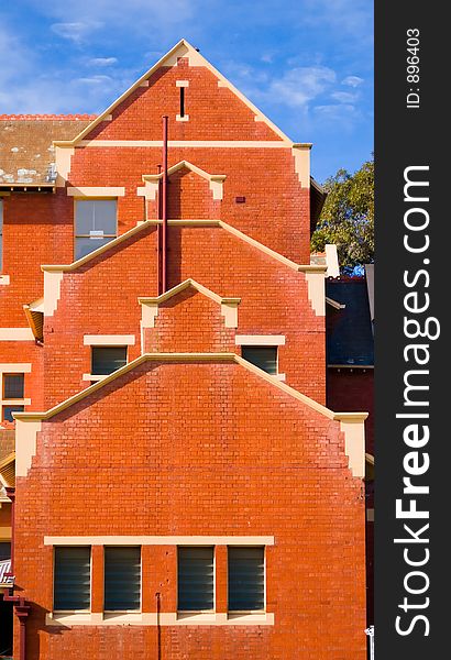 An unusual layered red brick three storey building. An unusual layered red brick three storey building.