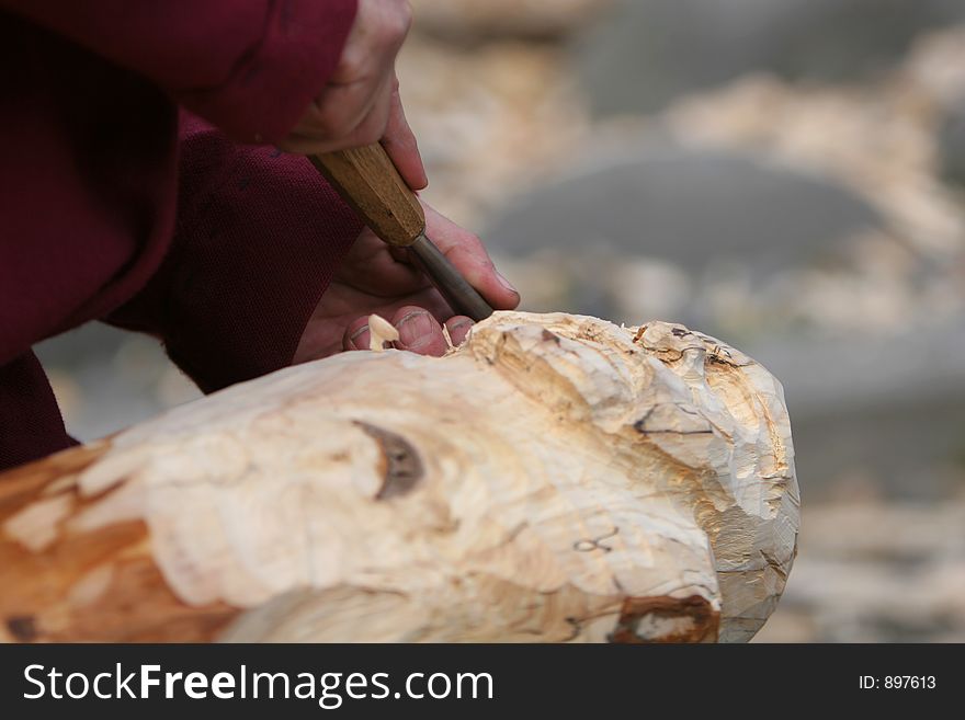 A craftsman working wood the oldfashioned way, carving a figure out of a piece of lumber. A craftsman working wood the oldfashioned way, carving a figure out of a piece of lumber