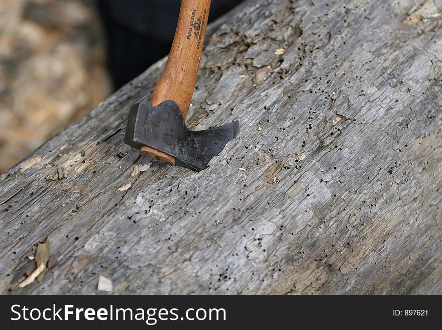 An axe buried into a piece of wood. An axe buried into a piece of wood