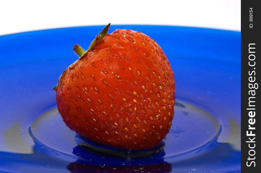 Strawberry on blue glass dish