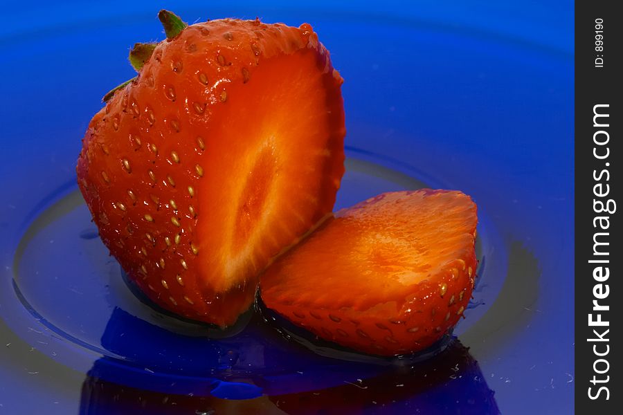 Sliced strawberry on blue glass dish