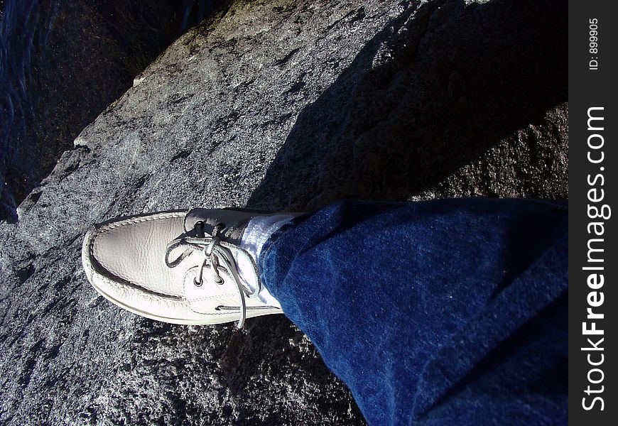 Standing on the edge of a rock with the ocean below