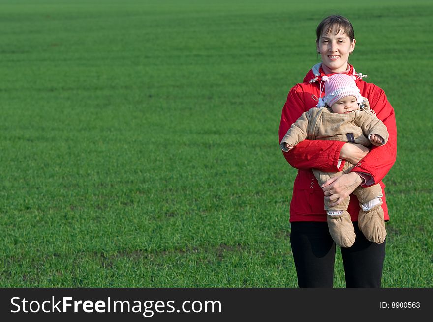 Little baby with mom on green grass background