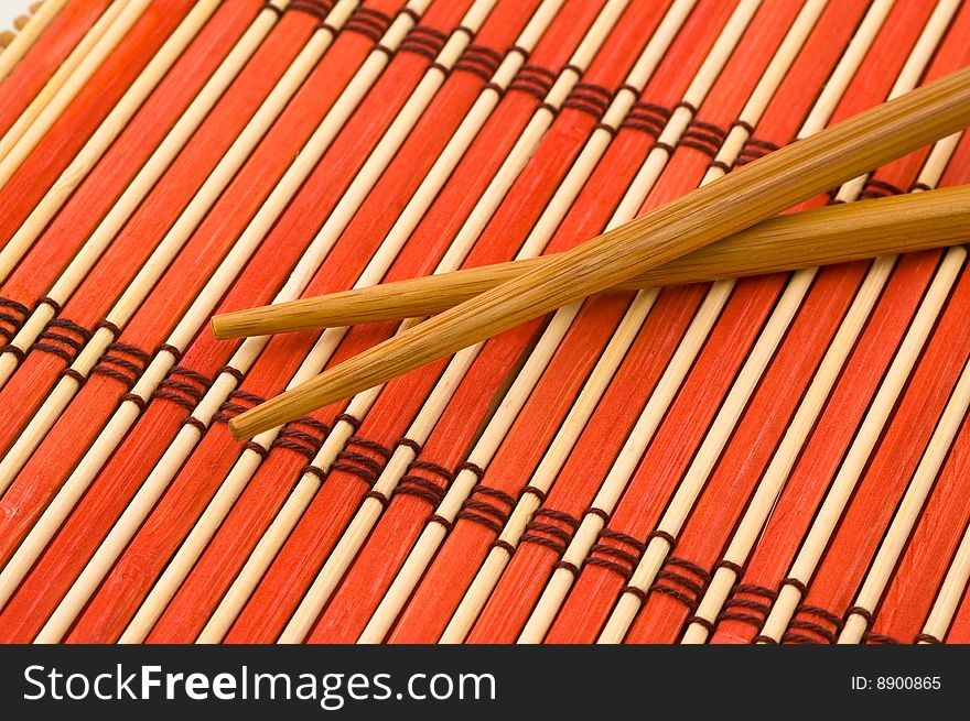 Pair of chinese chopsticks on bamboo mat. Pair of chinese chopsticks on bamboo mat.