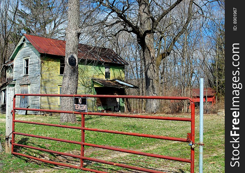 An abandoned falling down farm house sits on the side of the road. An abandoned falling down farm house sits on the side of the road.