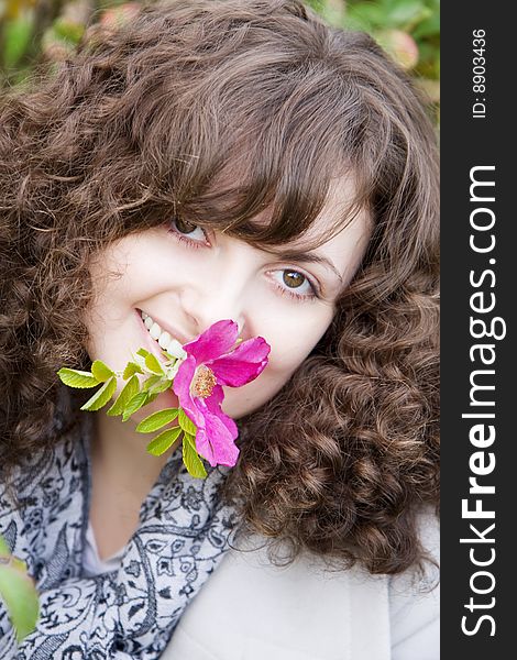 Girl on a background of flowers and fruits dogrose