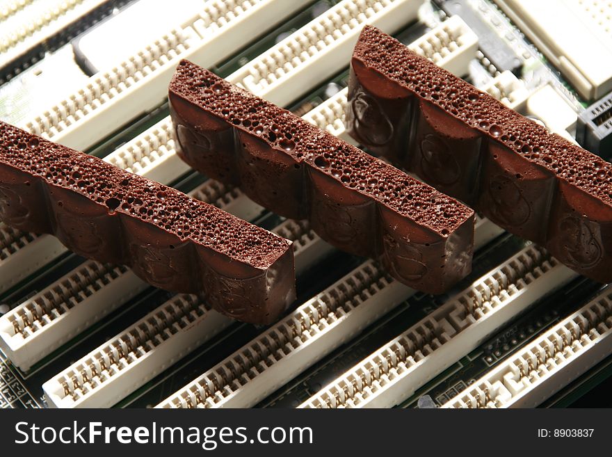 Slices of dark chocolate on a computer detail. Slices of dark chocolate on a computer detail.