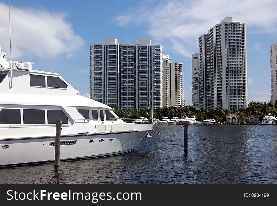 North Miami Beach marina with luxury yacht in the foreground and luxury highrise condo towers in the background