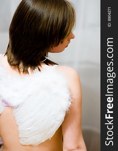 Beautiful girl with white wings behind their backs. Beautiful girl with white wings behind their backs