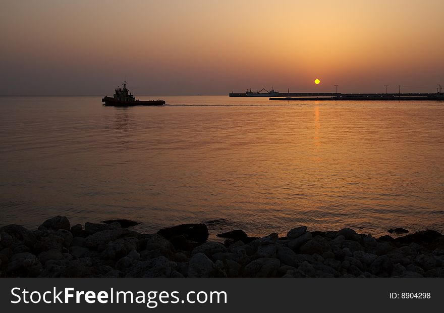 A tugboat puts out to sea at sunrise, Rhodes, Greece. A tugboat puts out to sea at sunrise, Rhodes, Greece