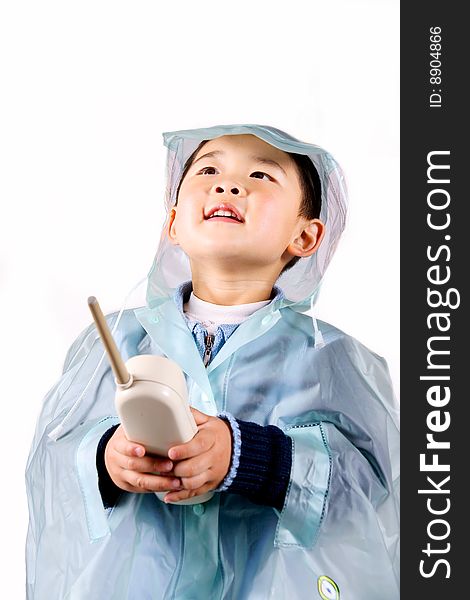 A picture of a little chinese boy holding a telephone in raincoat. A picture of a little chinese boy holding a telephone in raincoat