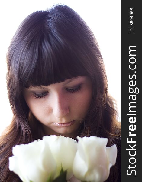 Girl sniffing beautiful flowers - white roses. Girl sniffing beautiful flowers - white roses