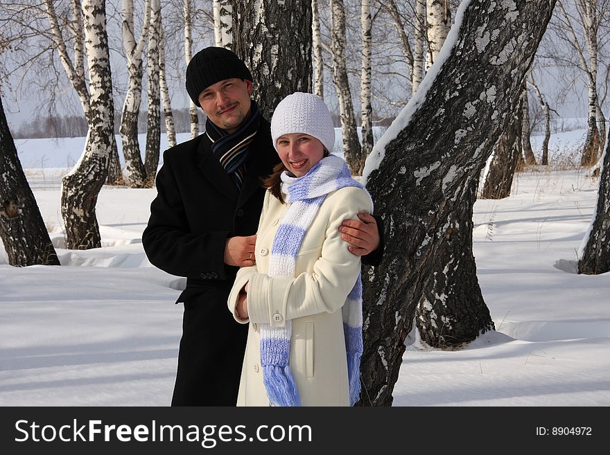 Couple the cold winter on a background of birches. Couple the cold winter on a background of birches