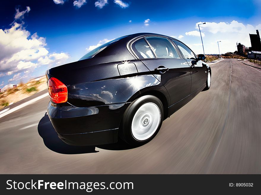 Black Sports Car in motion with deep blue sky. Black Sports Car in motion with deep blue sky