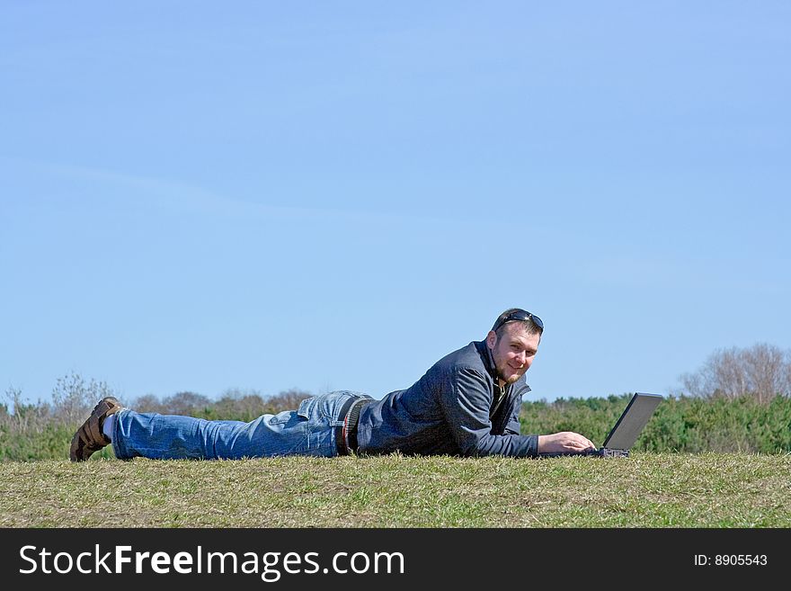 Man on meadow with laptop. Man on meadow with laptop