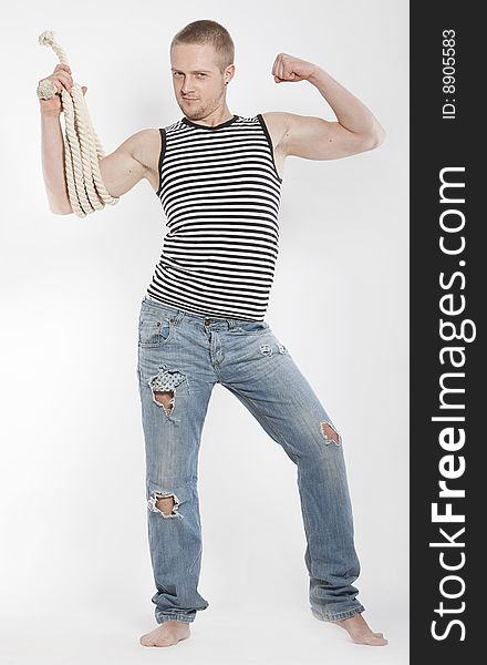 Powerfull man in old jeans with rope