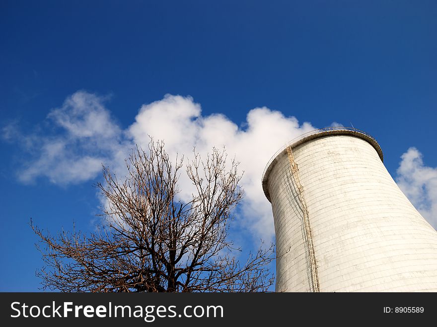 Smoking pipe and tree against the blue sky