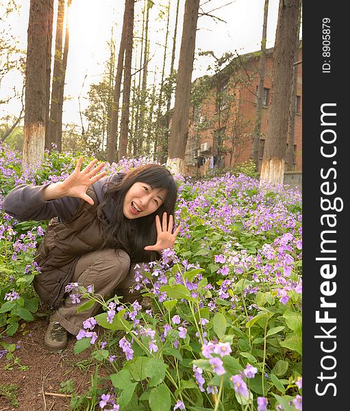 Chinese girl squatting in the flowers