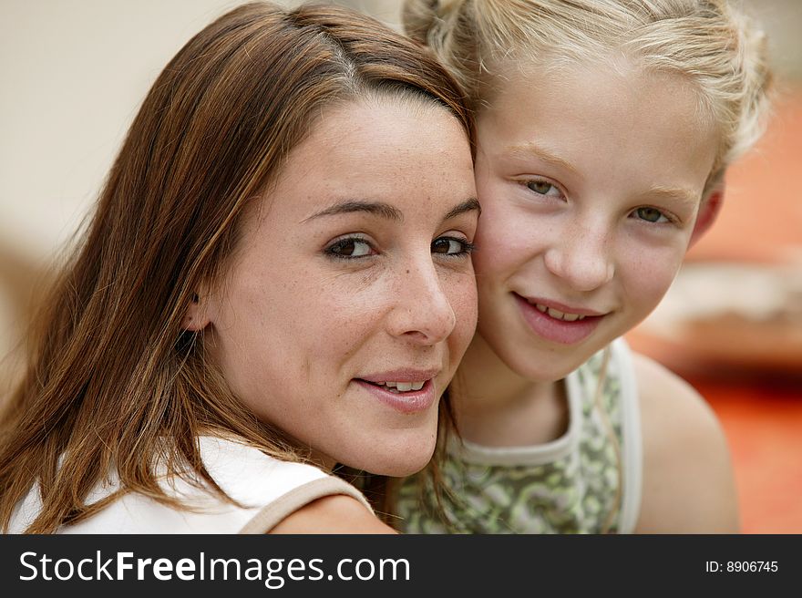 Portrait of a young woman with little girl smiling at camera. Portrait of a young woman with little girl smiling at camera