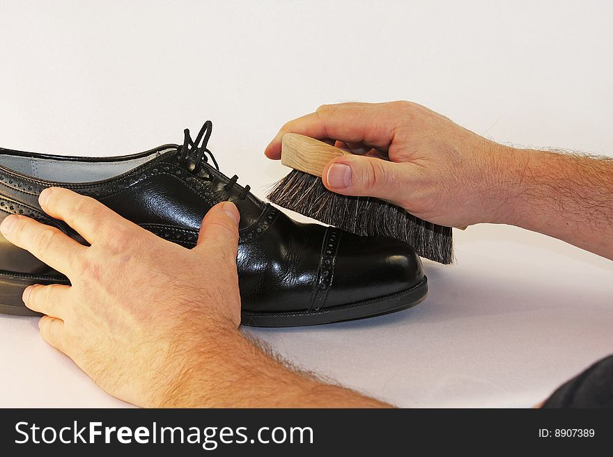 Buffinjg a polished black dress shoe with a shoe brush. Buffinjg a polished black dress shoe with a shoe brush