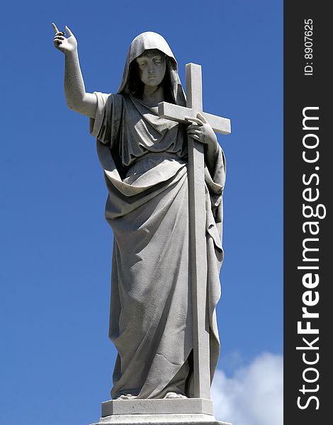 Marble statue with cross on the blue skies