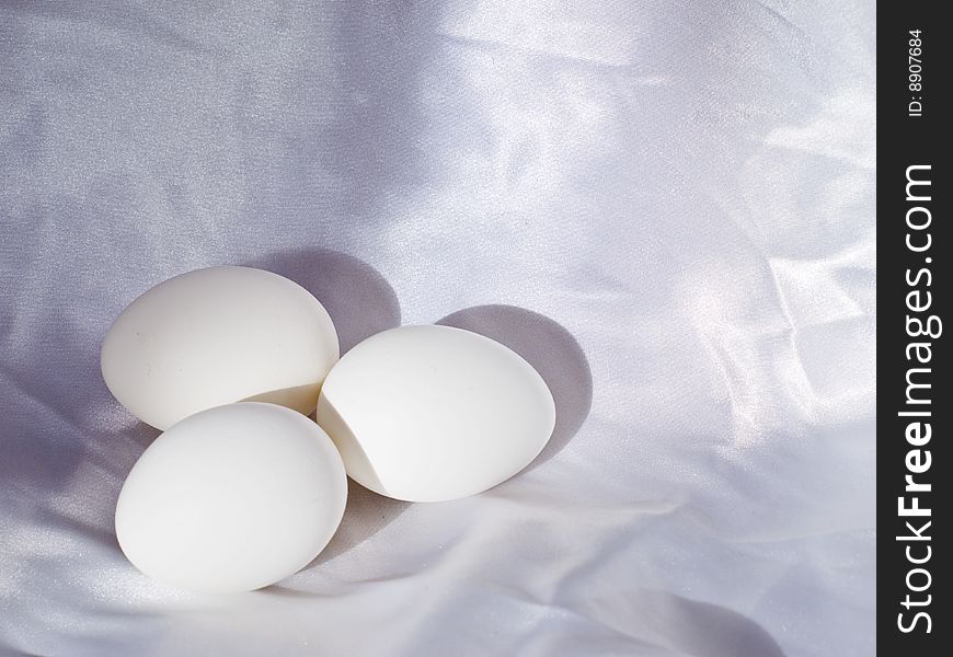 Three eggs on a white cloth