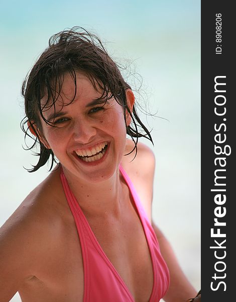 Woman in pink bikini at the beach smiling. Woman in pink bikini at the beach smiling