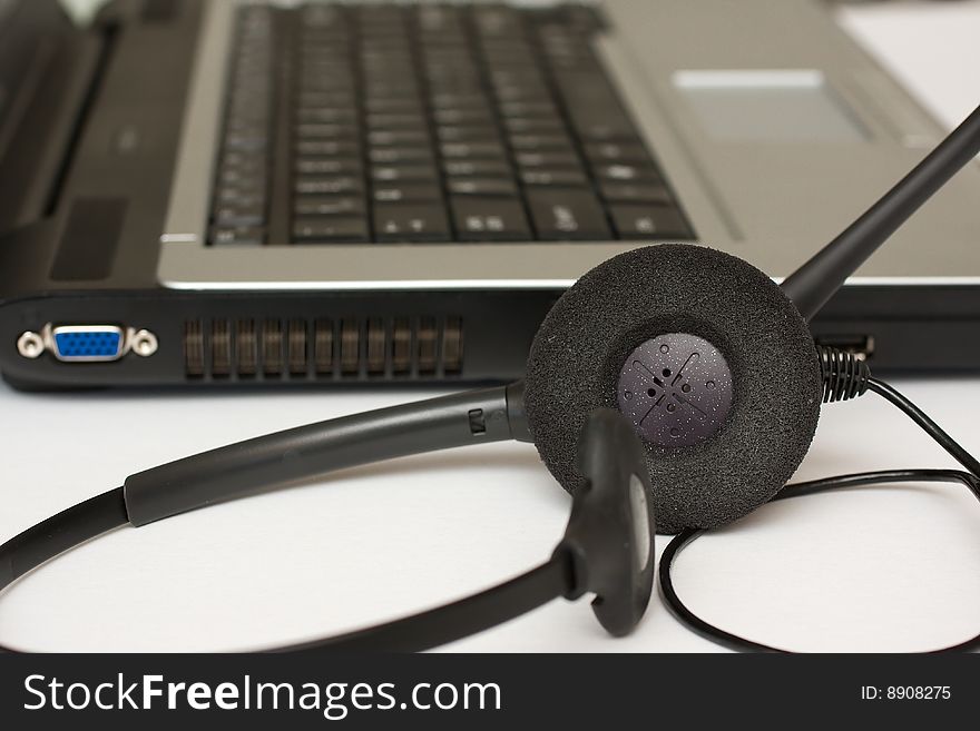 Telephone operator headset next to laptop possibly working from home