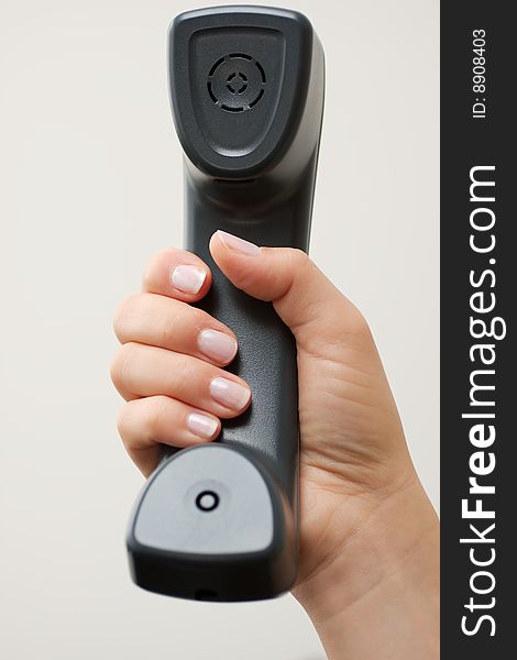 Female hand holding a business telephone handset. Female hand holding a business telephone handset