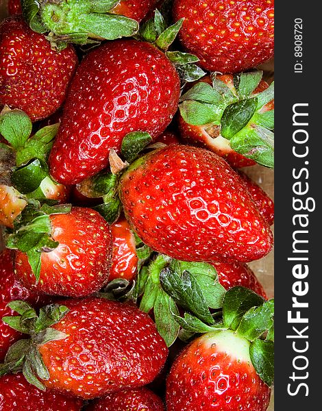 Macro image of fresh strawberries with leaves.