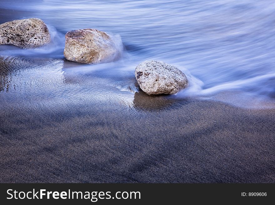 Long Exposed Wave Against Stones