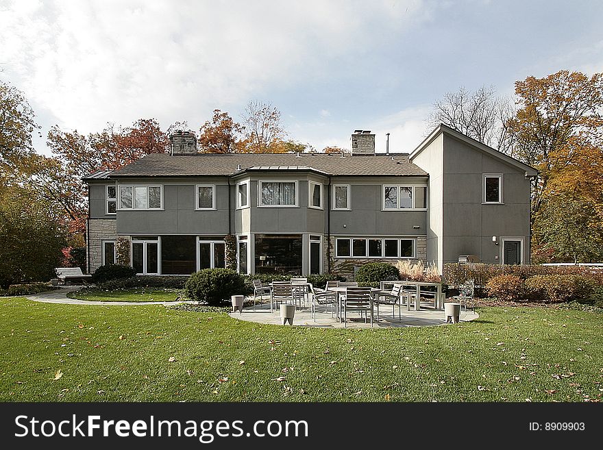 Rear view of luxury home with patio furniture