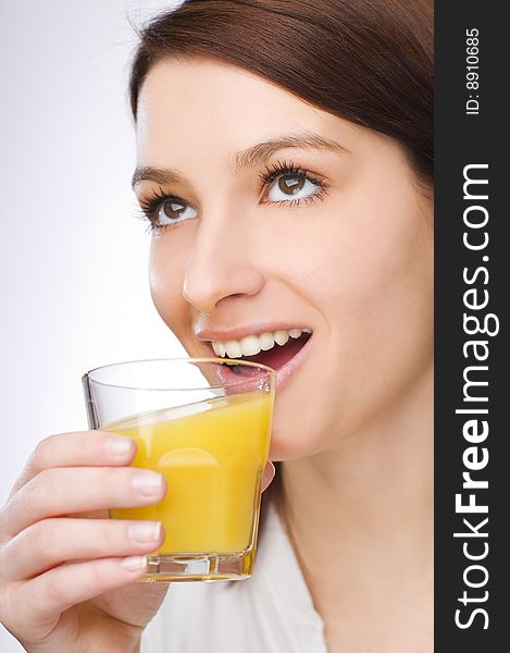 Young brunette woman drinking orange juice close up