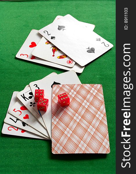 Cards and joker on the green background