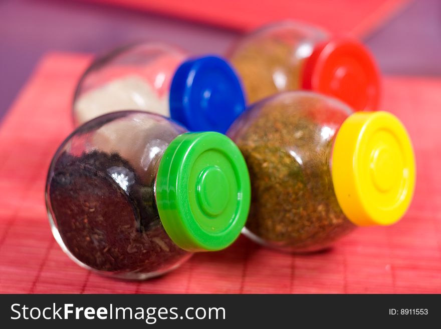 Four glass jars with spices and color covers