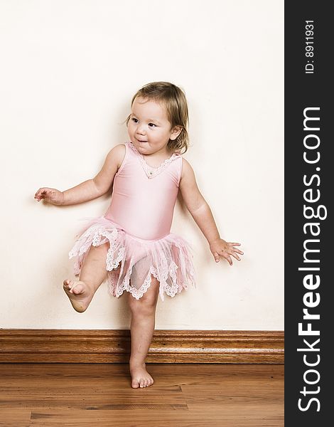 Little girl with short hair wearing a pink ballet outfit