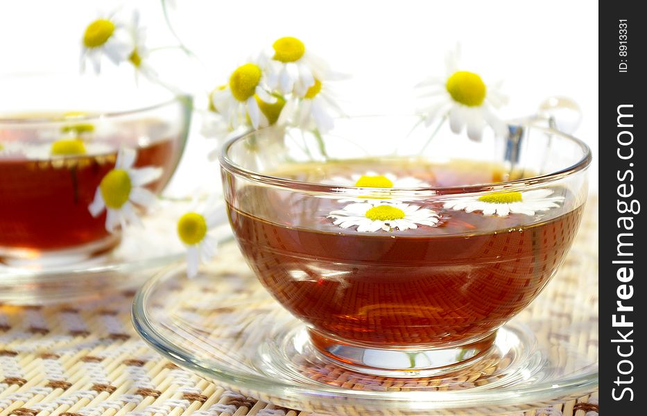 Cups of tea and chamomile blossoms