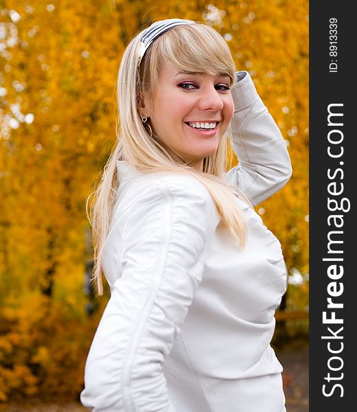 Pretty girl adjusting her hair - autumn park background - shallow DOF