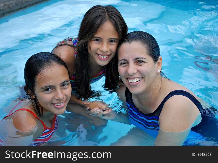 Mother with her beautiful  daughters in  the pool.