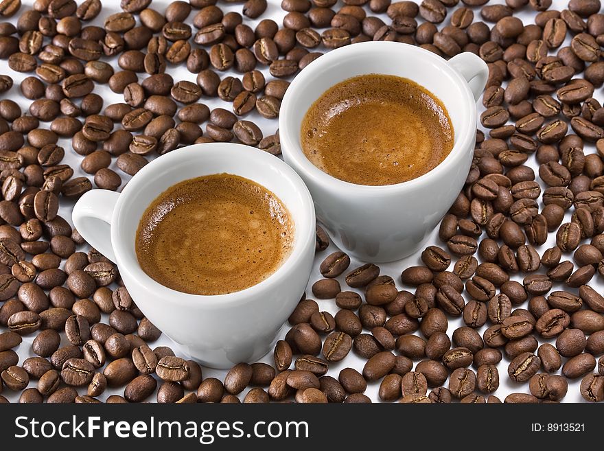 Two white coffee cups with coffee beans. Two white coffee cups with coffee beans