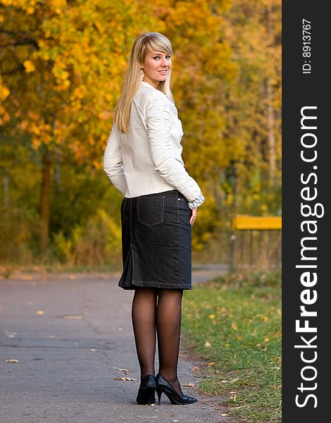 Pretty girl in white jacket on autumn park background - shallow DOF
